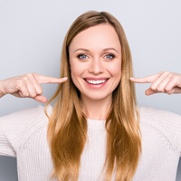 woman pointing to smile after Invisalign treatment