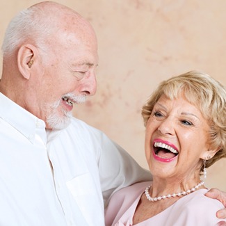 Older man and woman laughing together after all-on-4 dental implant placement