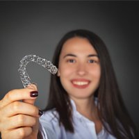 woman holding Invisalign tray