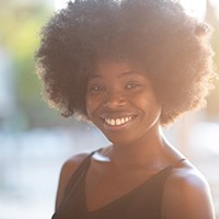 person smiling and walking in a park