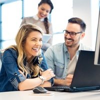 A group of employees smiling and working.