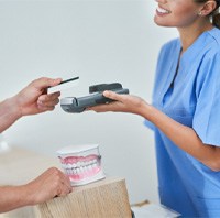 A patient paying the cost of cosmetic dentistry 