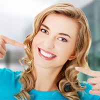 A woman pointing to her perfect smile