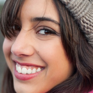 A young woman smiling after Invisalign treatment