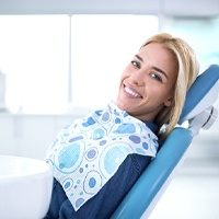 Woman in dental chair using her insurance coverage.