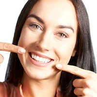 Woman pointing to a healthy smile.