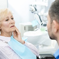 senior woman with a toothache visiting her emergency dentist in Parker 