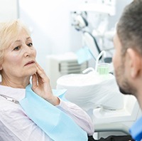 senior woman with a toothache visiting her emergency dentist 