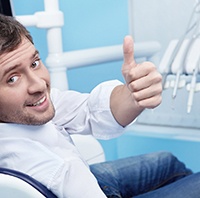 Male dental patient giving a thumbs up