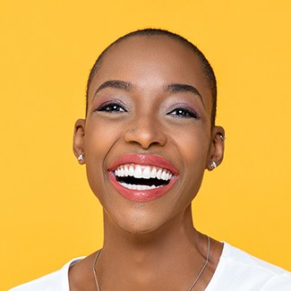 A young woman showing off her healthy, beautiful smile after completing treatment with Invisalign in Parker