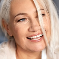 woman smiling after getting dental implants in Parker