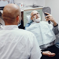 man beaming at his new dental implants in Parker 