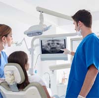 implant dentist showing a patient X-rays of their mouth