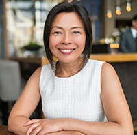 Woman with dental implants sitting in a restaurant.