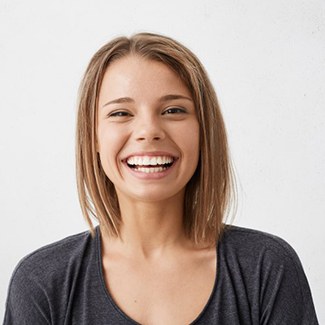 young woman in black shirt with straight teeth thanks to Invisalign in Parker