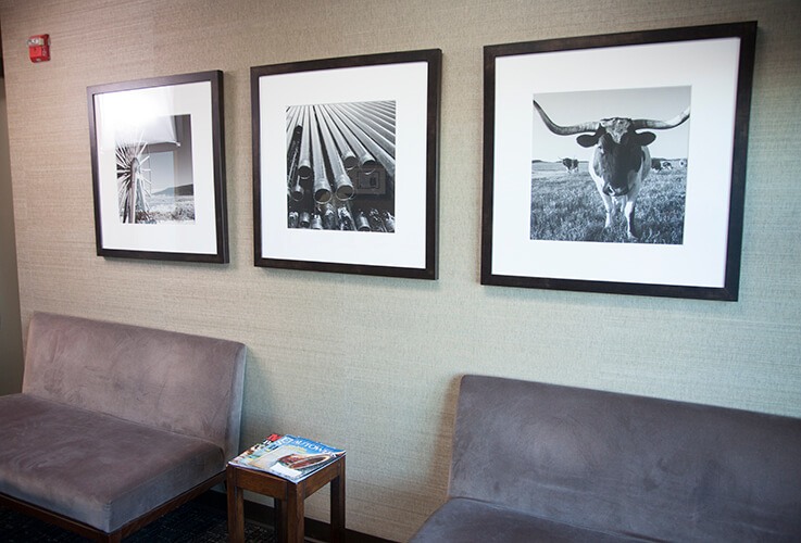 Dental office waiting area with couches and pictures
