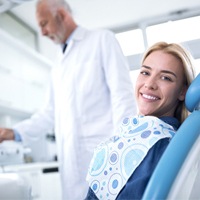 Woman smiling in dental chair for oral cancer screening