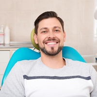 Man smiling in dental chair during oral cancer screening