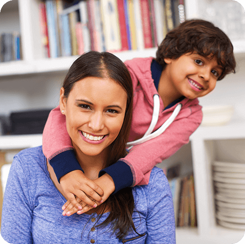 Child hugging their mother from behind in living room