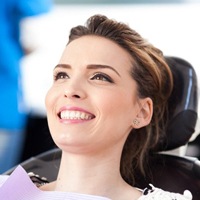 woman smiling in dental chair after periodontal therapy