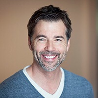 Smiling Man wearing blue sweater after porcelain veneer placement