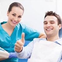 Man in dental chair giving thumbs up after root canal