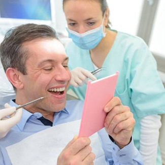 Smiling man in dental chair after root canal therapy