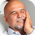Man wincing from teeth pain