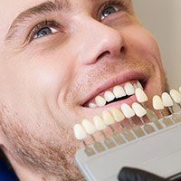 doctor using tooth shade chart on patient