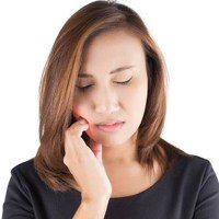 woman with toothache in need of tooth extraction