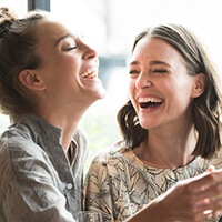 two women laughing after tooth-colored filling placement