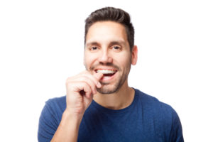 Man placing his subtle, clear Invisalign tray