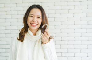 girl holding aligner for Invisalign in Parker