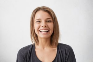 girl in black shirt smiling with dental implants