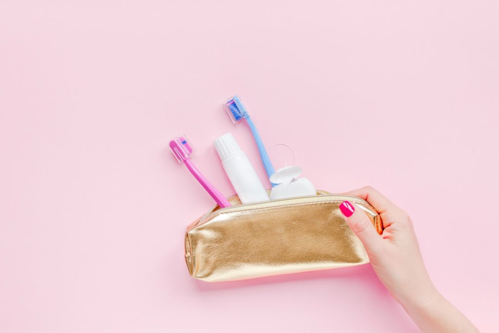 Woman holding dental hygiene to-go kit