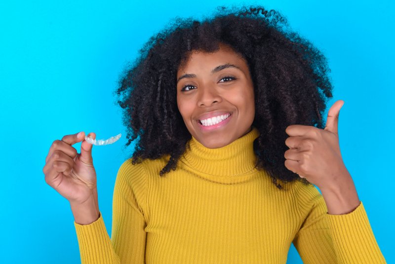 woman giving thumbs up about Invisalign questions in Parker