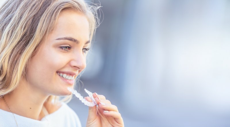 a woman holding her Invisalign aligner
