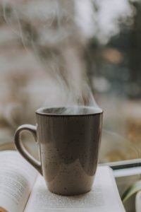 Steaming coffee cup on opened book