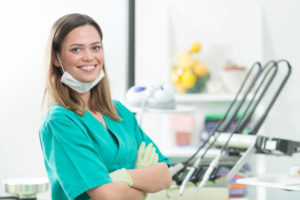 Female dental hygienist in green scrubs
