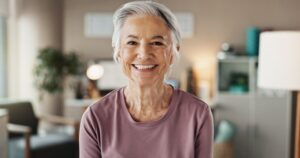 Older woman smiling with dentures.